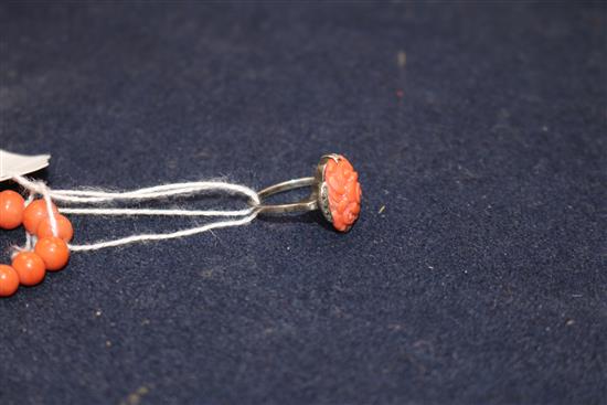A single strand graduated coral bead necklace and a carved coral ring.
